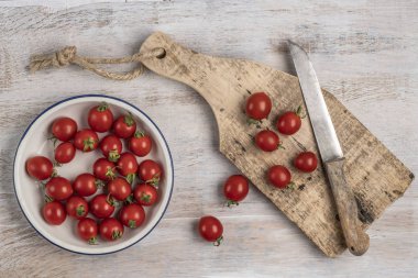 ahşap bir masada olgun kiraz domates ve bıçak
