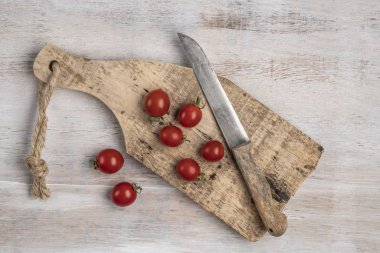 ahşap bir masada olgun kiraz domates ve bıçak