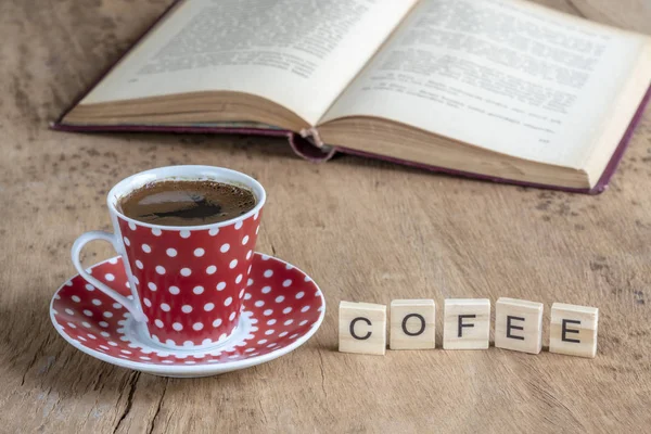 Book and coffee cup on table with the word of coffee