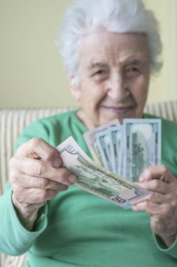 Amerikan Doları 'nı tutan ve veren son sınıf öğrencisi bir kadın.