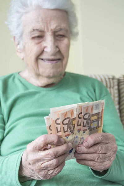 A senior woman counting Euro banknotes — Stock Photo, Image