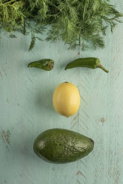 Tahta bir masada taze sebzelerle yapılmış yüz şekli.