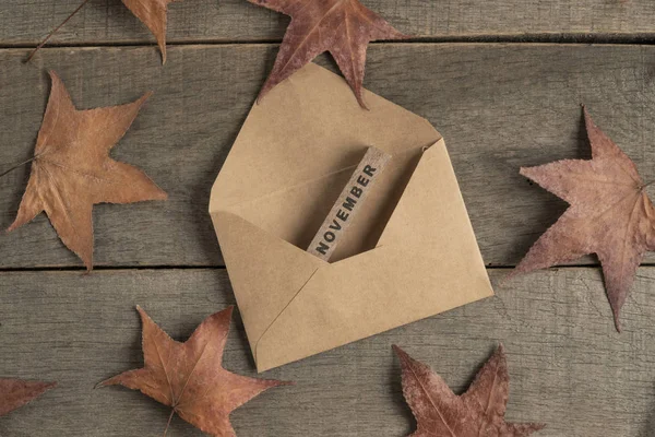 Modèle de novembre avec enveloppe et feuilles d'automne sur la table — Photo