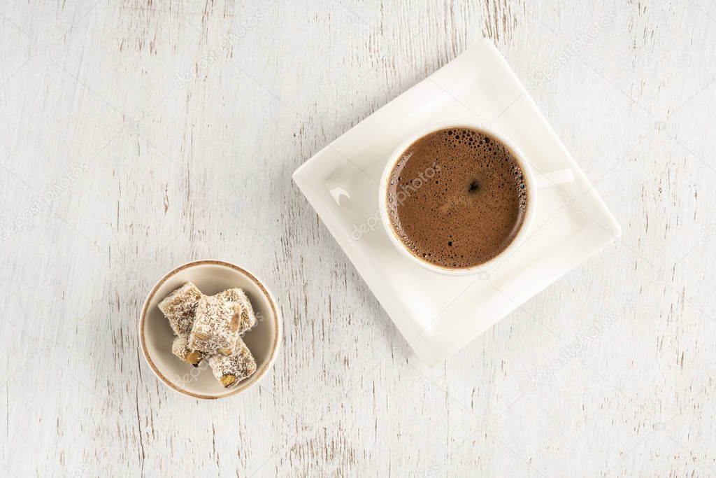 A cup of Turkish coffee and delight on a wooden table