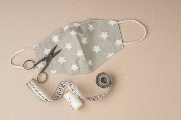 closeup of tailor made textile health mask with sewing tools