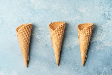 Fotokopi alanı olan mavi bir zemin üzerinde boş waffle dondurma külahları