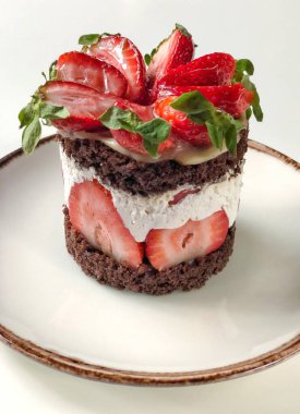 Masadaki çilekli ve çikolatalı kekin yakın çekimi. 