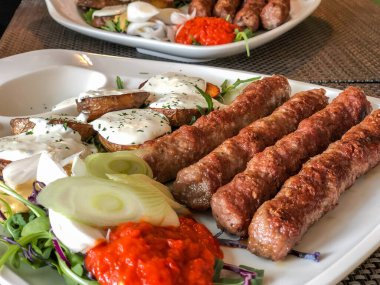 Slovanski köftesi ve tabağında salata olan patates.