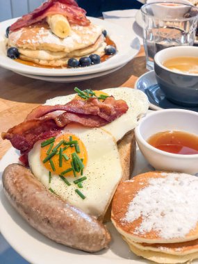 Bir kafede yumurta, krep ve sosisli kahvaltı.
