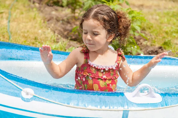 在充满水的充气小船里玩耍的小女孩 — 图库照片