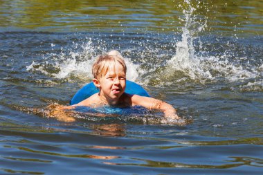 Şişme deniz ringde ile küçük çocuk yüzüyor