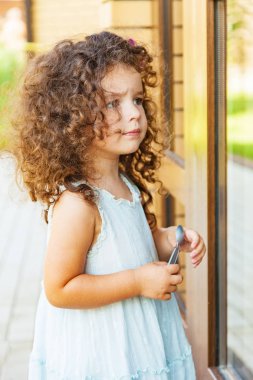 Küçük kız kapalı kapıyı çalıyor