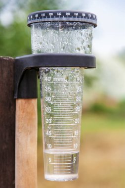 Meteorology with rain gauge in garden, measurement of precipitation clipart