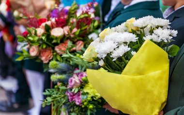 Çocukların, ellerinde çiçek demetleri tatil okula dönüş