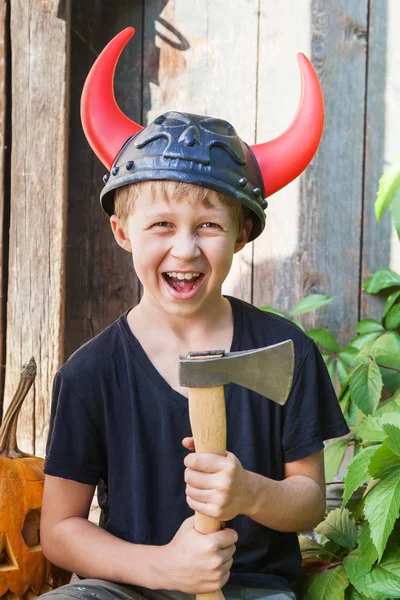 在角维京头盔男孩拿斧头在户外 在后台的南瓜万圣节 — 图库照片