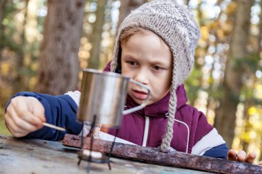 Metal kupa çay ile bir yangın yangın, açık havada, yakın çekim, çocuk ışıklar üzerinde ısıtılır