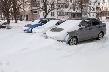 Bir kar fırtınası sonra park yerinde kar kaplı arabalar