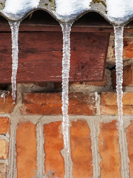 Eiszapfen Auf Dem Dach Des Hauses Vor Ziegelmauer Winterhintergrund — Stockfoto