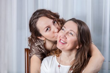 Mutlu kızı onun gülümseyen Anne, portre portre studio kisses