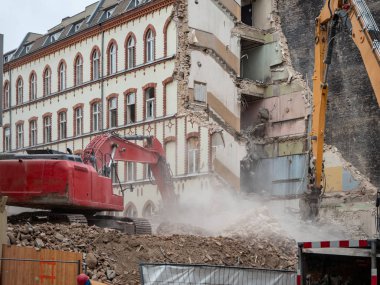 İmar, Berlin, Almanya için evler yıkan kazıcı. Eski bina duvarları ve bir ekskavatör kova ile inşaat enkaz Temizleme