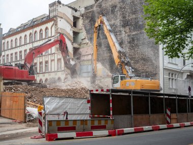 İmar, Berlin, Almanya için evler yıkan kazıcı. Eski bina duvarları ve bir ekskavatör kova ile inşaat enkaz Temizleme
