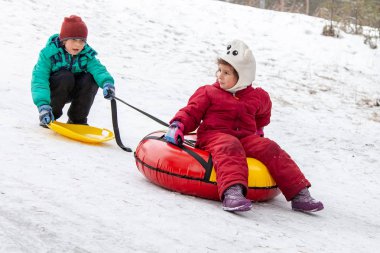 Kardeş kardeş kızaklarımız hill açık havada, kış günü, kış oyunları ve eğlenceli boru çeker