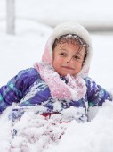 Malá holčička hraje venku na sněhu
