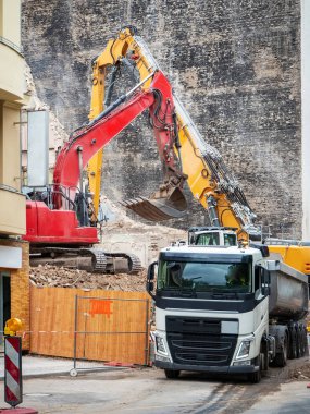 İmar, Berlin, Almanya için evler yıkan kazıcı. Eski bina, bir ekskavatör kova ile inşaat enkaz Temizleme ve bir damperli kamyon yükleme duvarlar imha