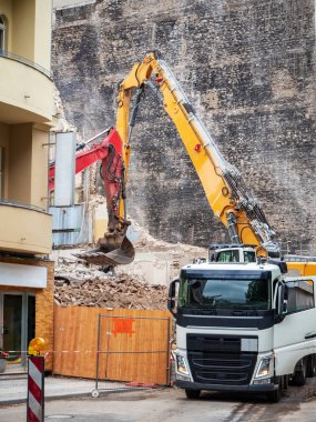 İmar, Berlin, Almanya için evler yıkan kazıcı. Eski bina, bir ekskavatör kova ile inşaat enkaz Temizleme ve bir damperli kamyon yükleme duvarlar imha