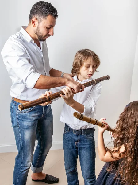 Papà insegna ai bambini a suonare il flauto di bambù — Foto Stock