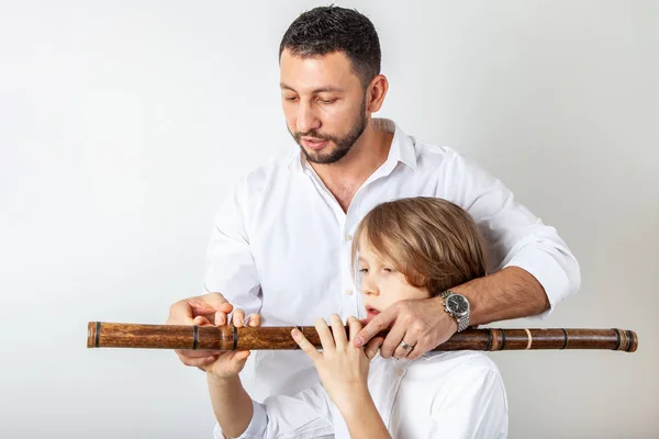 Father teaches son to play bamboo flute — Stock Photo, Image