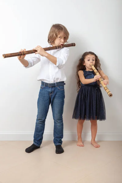 Chłopiec i dziewczynka gra bambusowy flet — Zdjęcie stockowe