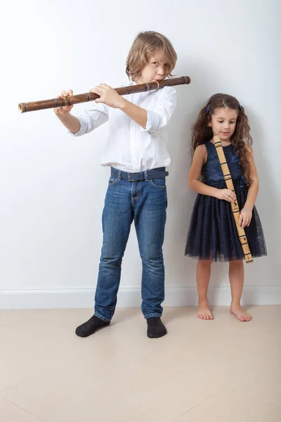 Boy and girl playing bamboo flute — Stock Photo, Image