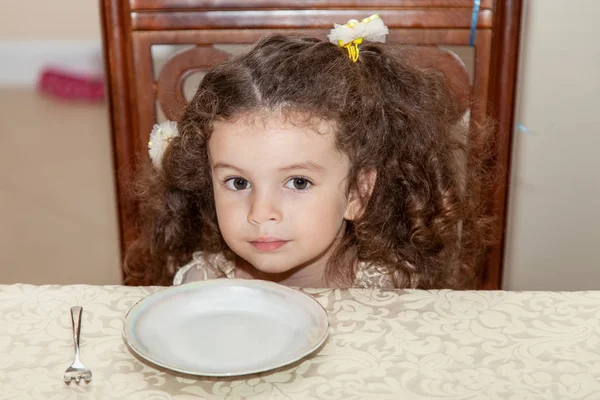 Klein meisje hongerig en wachten op eten — Stockfoto