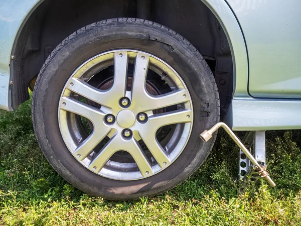 Carro com pneu danificado no macaco — Fotografia de Stock