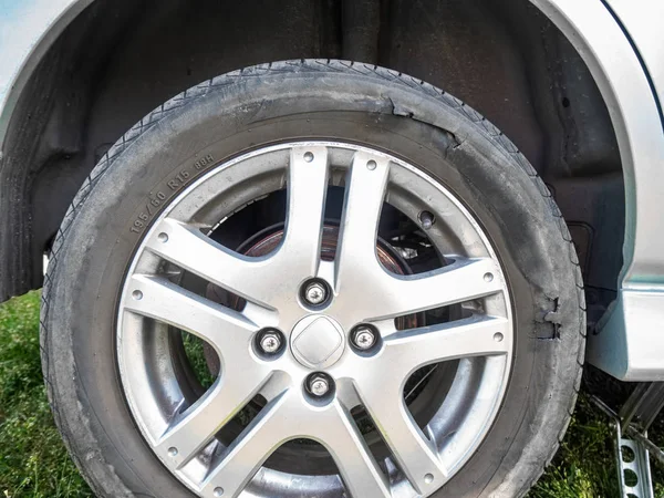 Neumático de coche dañado con un agujero —  Fotos de Stock