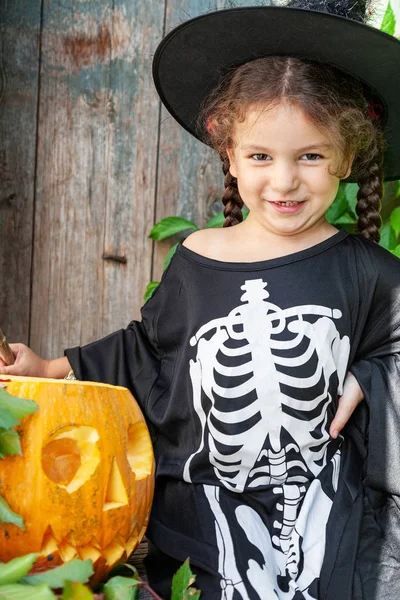 Bruxinha com abóbora de Halloween — Fotografia de Stock