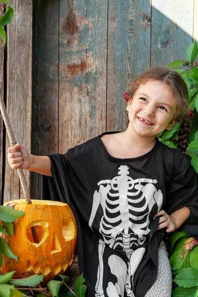 Kleine Hexe mit Halloween-Kürbis — Stockfoto