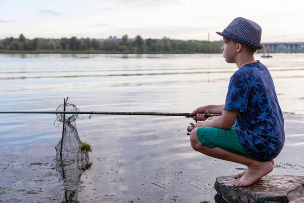 釣竿を持った少年が魚を捕まえる — ストック写真