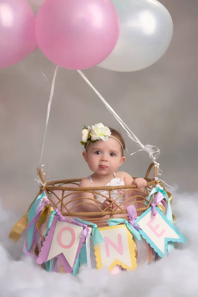 一岁的白种女孩在可爱的热气球篮为第一个生日 — 图库照片
