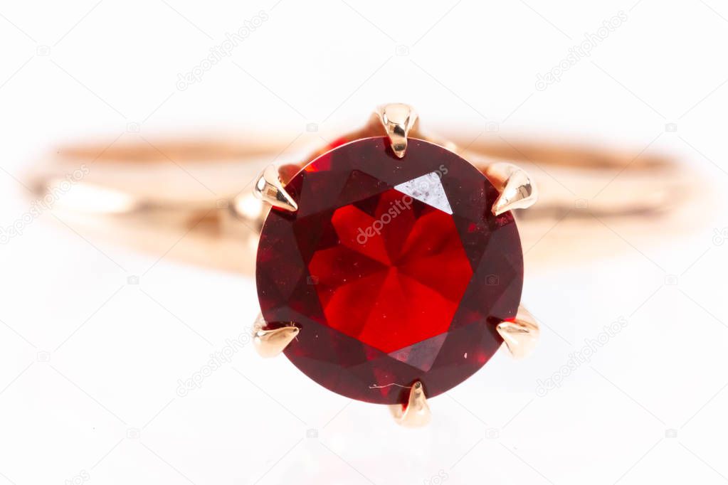 Closeup of imperfect ruby gemstone set in gold ring showing scratches