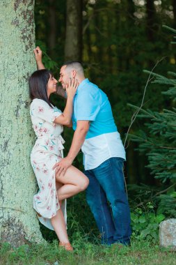 Genç nişanlı çift ağaç öpüşme dışında birbirlerine aşık özel bir an tadını çıkarın
