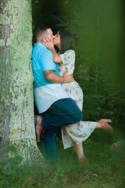 Genç nişanlı çift ağaç öpüşme dışında birbirlerine aşık özel bir an tadını çıkarın