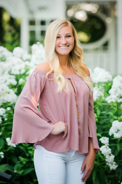 Üst düzey fotoğraf için poz bir çekici sarı saçlı beyaz lise son sınıf öğrencisi. Yaz aylarında açık havada Park'ta kadın genç portre ayakta.