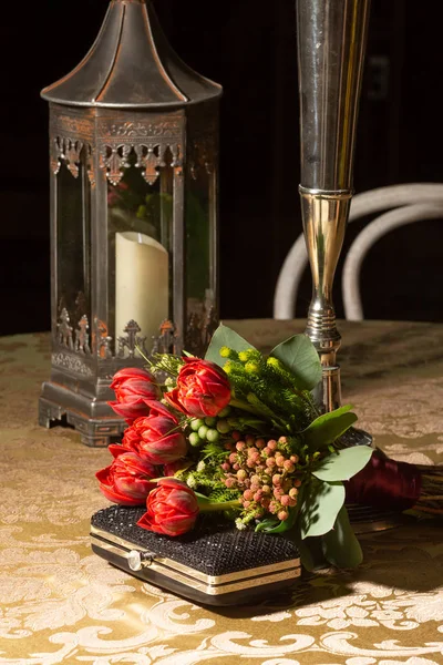 Fowers と正式なイベント 結婚式やパーティーのフォーマルなテーブルの黒のクラッチの美しい赤いチューリップの花束 — ストック写真