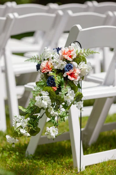 Hochzeitszeremonie im Freien mit künstlichen Blumen auf weißen Stühlen — Stockfoto