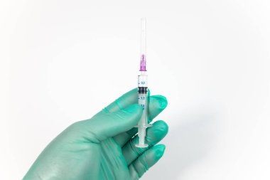Tıbbi bir eldiven üzerinde beyaz izole şırınga tutarak el