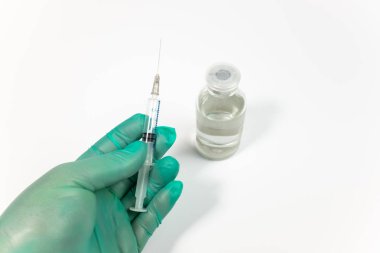 Tıbbi bir eldiven üzerinde beyaz izole şırınga tutarak el