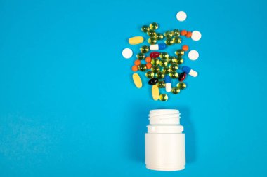 Şişe mavi zemin üzerine çeşitli hap