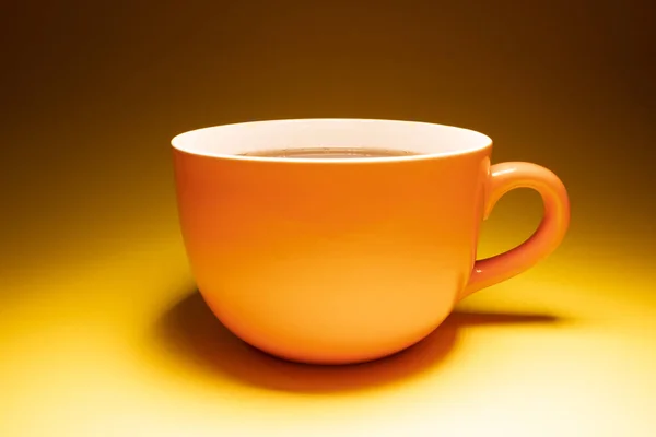 Taza Naranja Sobre Fondo Amarillo —  Fotos de Stock